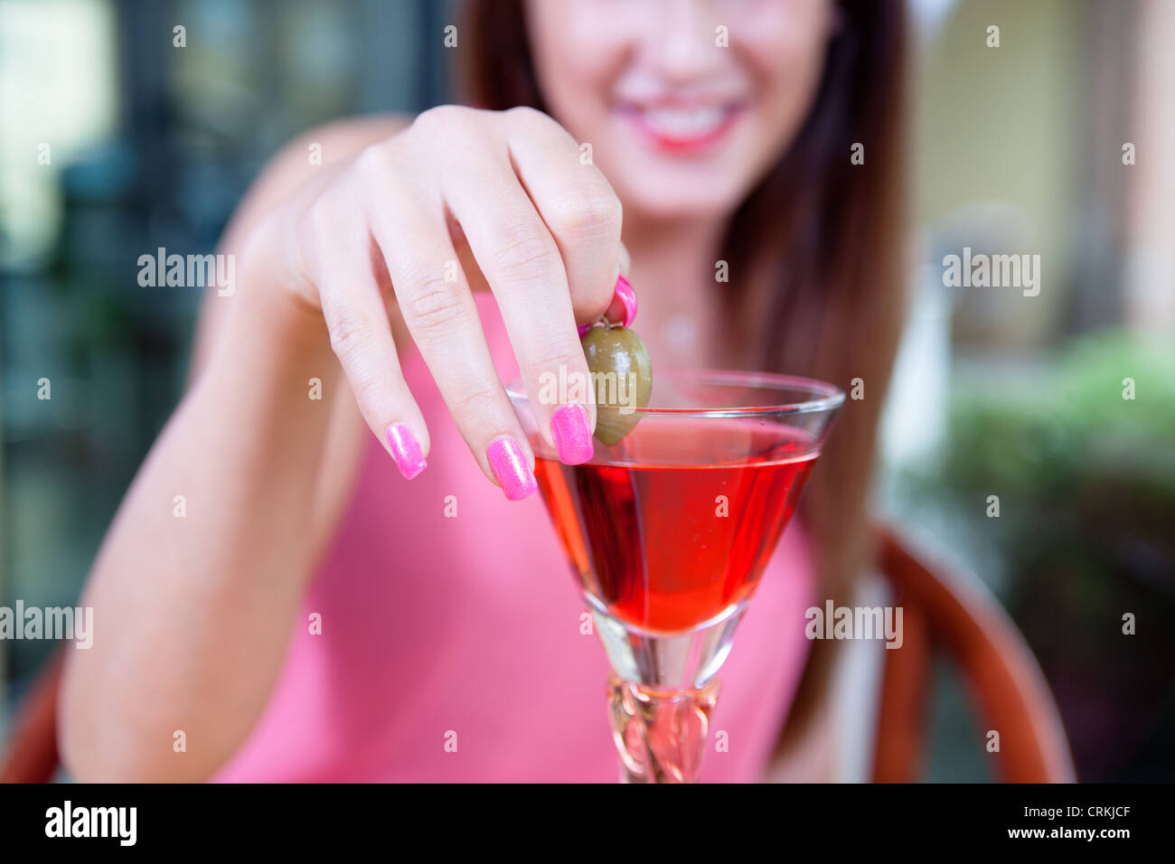 Femme tenant un rameau d'un verre de Campari Banque D'Images