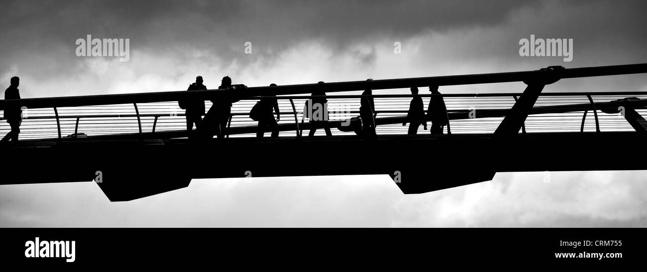 Silhouette de personnes traversant le pont du millénaire Banque D'Images