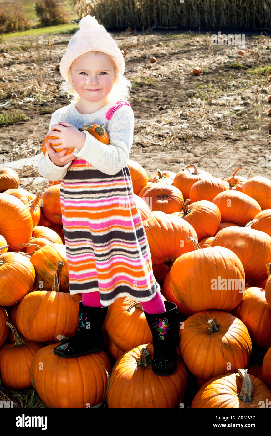 Portrait d'une jeune fille debout sur pumpkin Banque D'Images