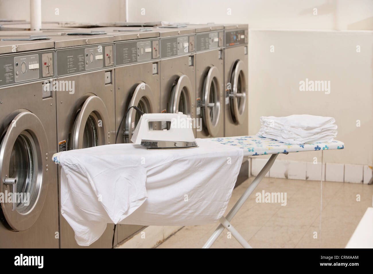 Planche à repasser avec des machines à laver dans la buanderie Banque D'Images