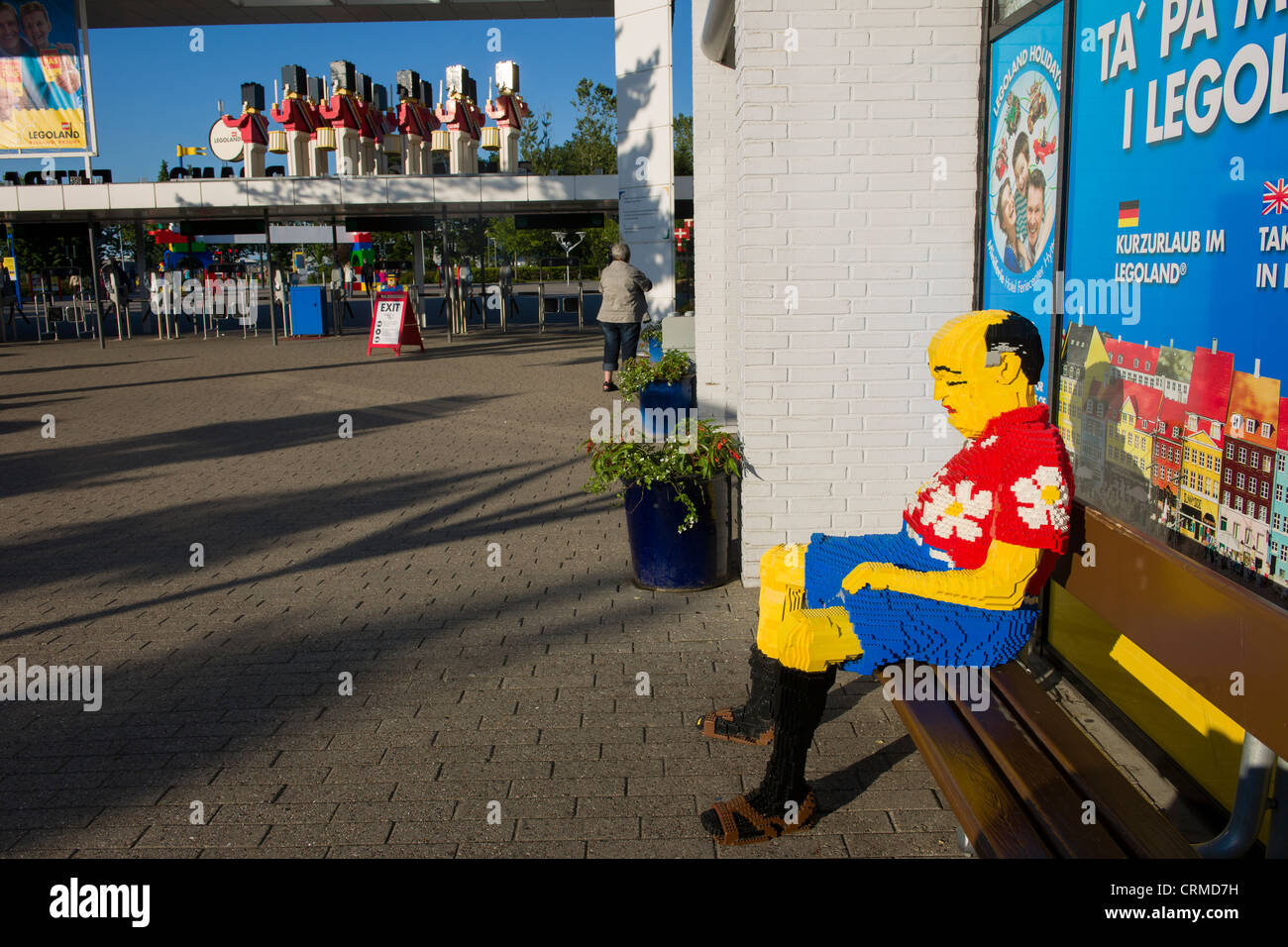 Touristiques Lego dormir sur un banc par l'entrée principale du parc Legoland, à Billund, Danemark Banque D'Images