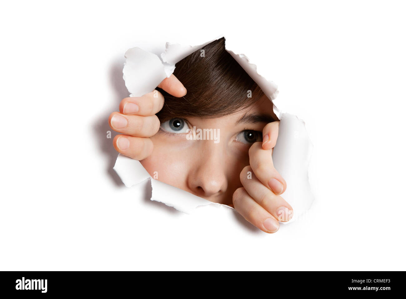 Middle Eastern woman peeking de papier déchiré trou blanc Banque D'Images