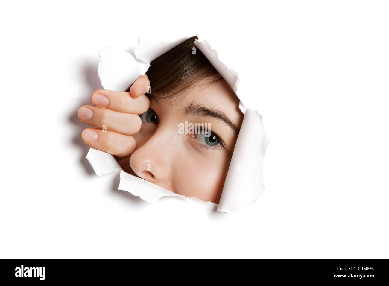 Portrait d'une jeune Middle Eastern woman peeking de papier blanc déchiré trou Banque D'Images