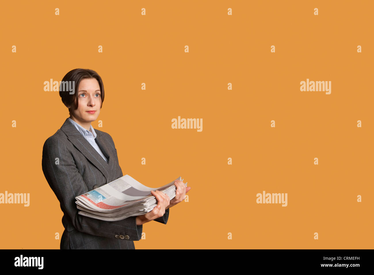 Mid adult woman holding pile de journaux Banque D'Images