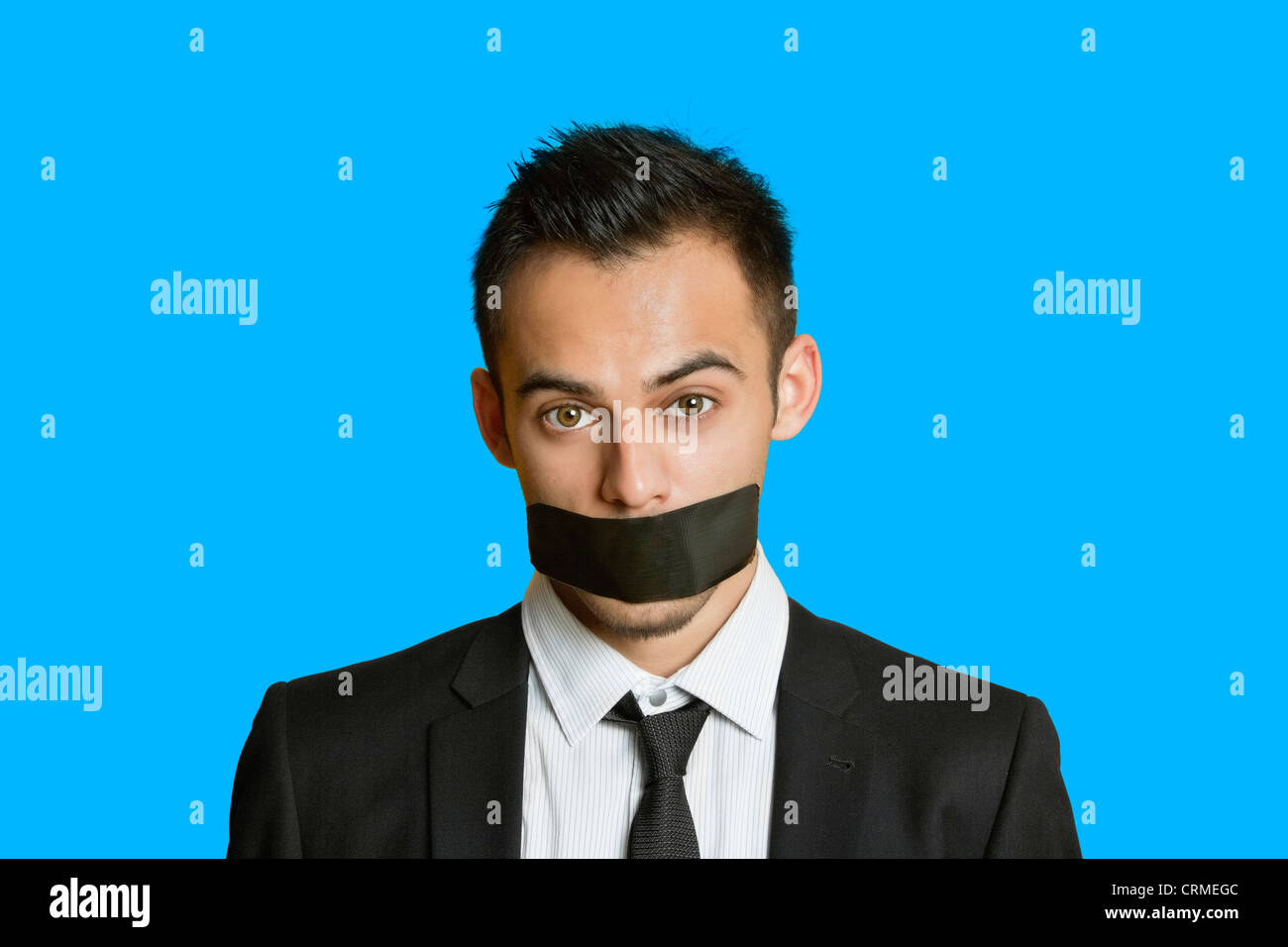 Portrait d'un jeune homme avec du ruban adhésif sur la bouche sur fond de couleur Banque D'Images