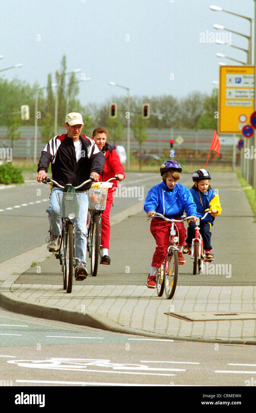Les parents avec leurs enfants en faisant du vélo sur la route Banque D'Images