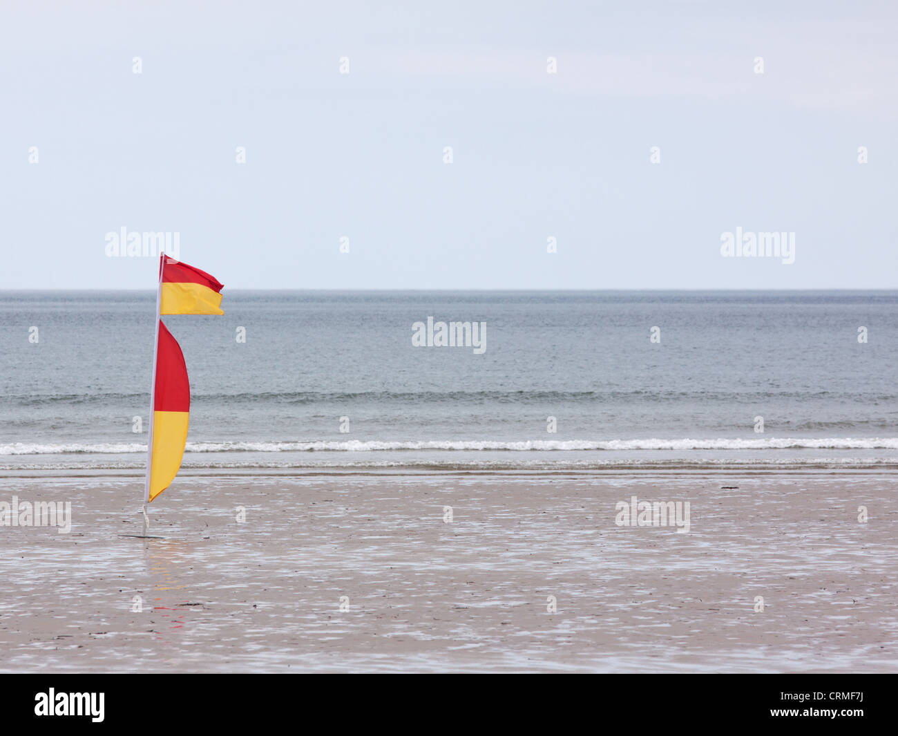 Drapeau rouge et jaune sur la plage à Westward Ho !, Angleterre indiquant une baignade sûre et surf zone surveillée par des sauveteurs Banque D'Images