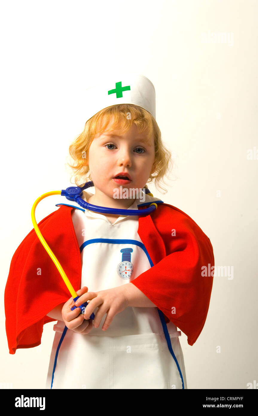 Une jeune fille habillée comme une infirmière, avec un jouet stéthoscope autour du cou Banque D'Images