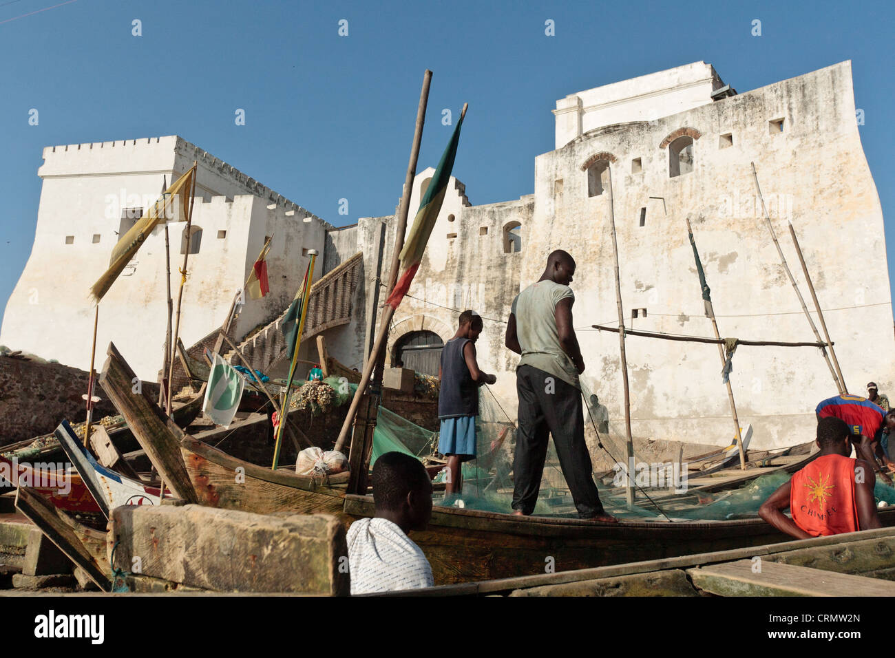 Les hommes sur des bateaux de pêche près de Cape Coast Castle, Cape Coast, Ghana Banque D'Images