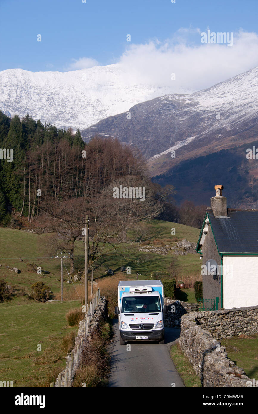 Tesco home delivery van stationné à l'extérieur de la maison avec la neige en arrière-plan le Mont Snowdon Gwynedd North Wales UK Banque D'Images