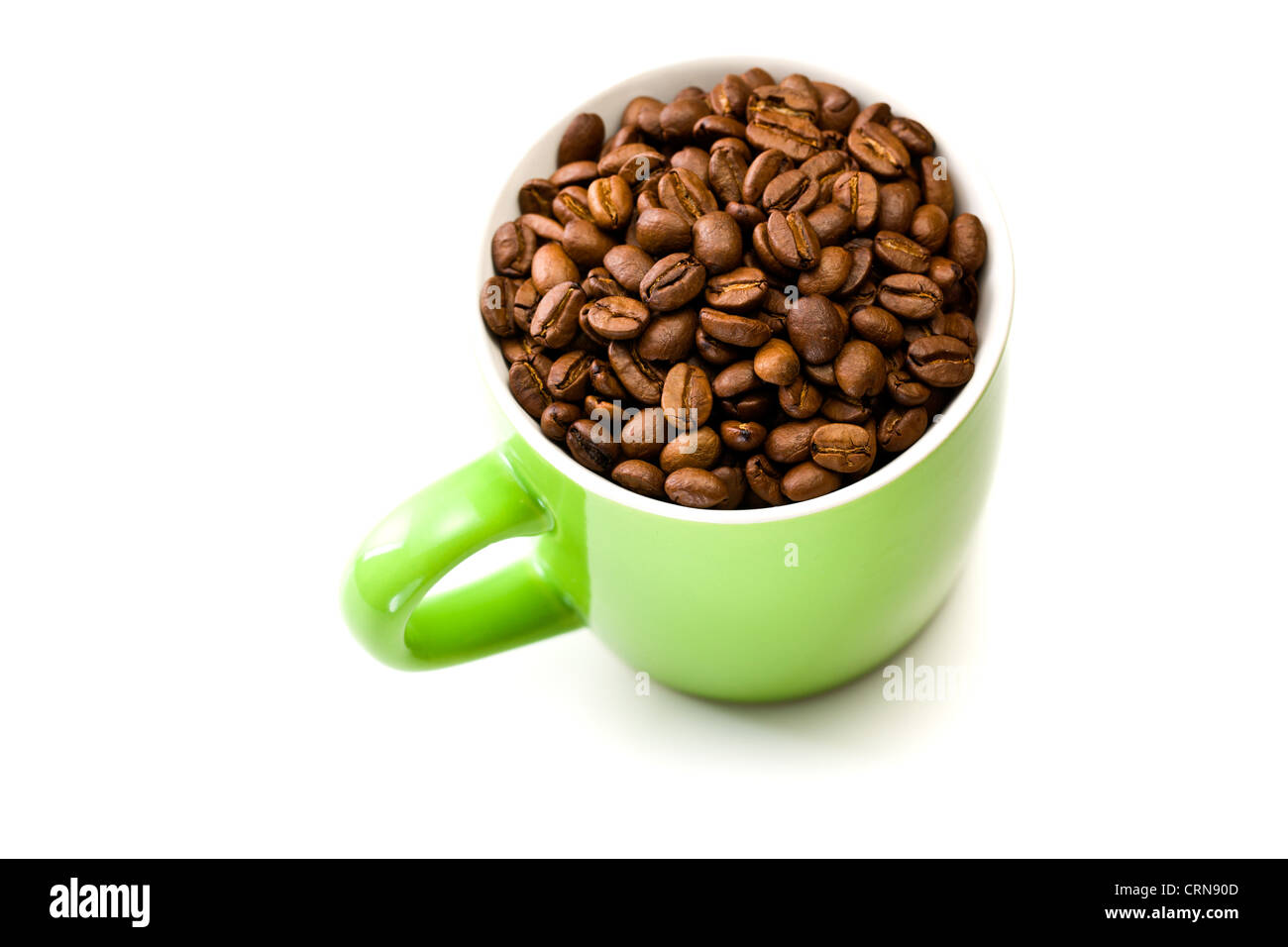 Mug coloré avec les grains de café sur fond blanc Banque D'Images