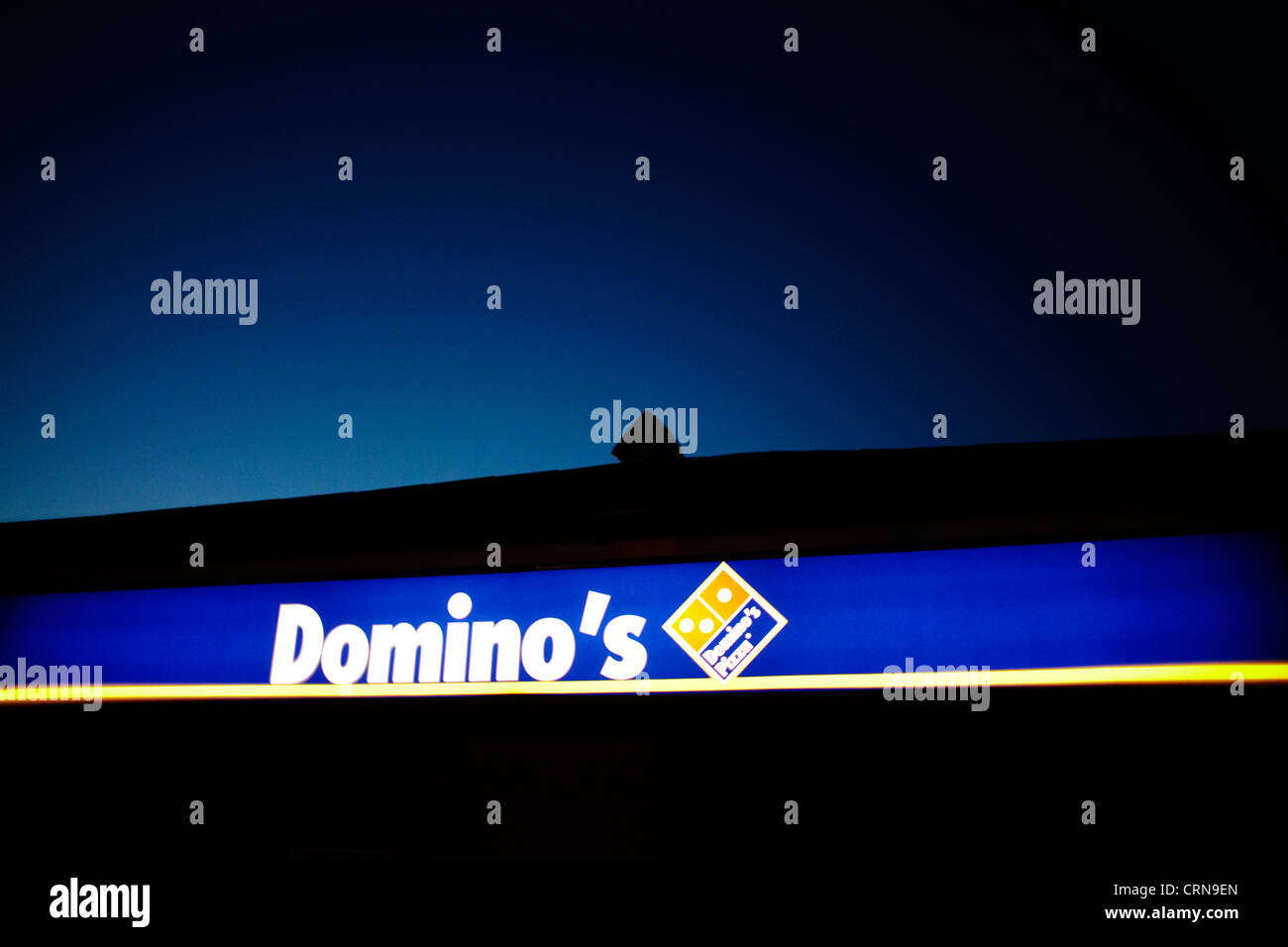 Domino's Pizza s'illuminèrent contre un ciel de nuit Banque D'Images
