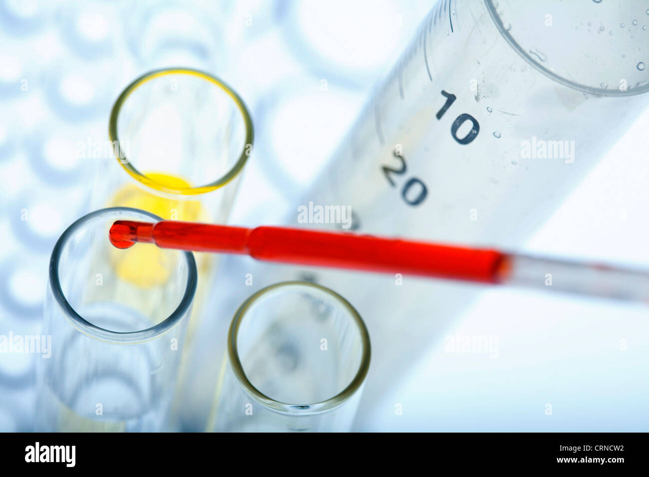 Le pipetage liquide rouge dans les tubes à essai. Banque D'Images