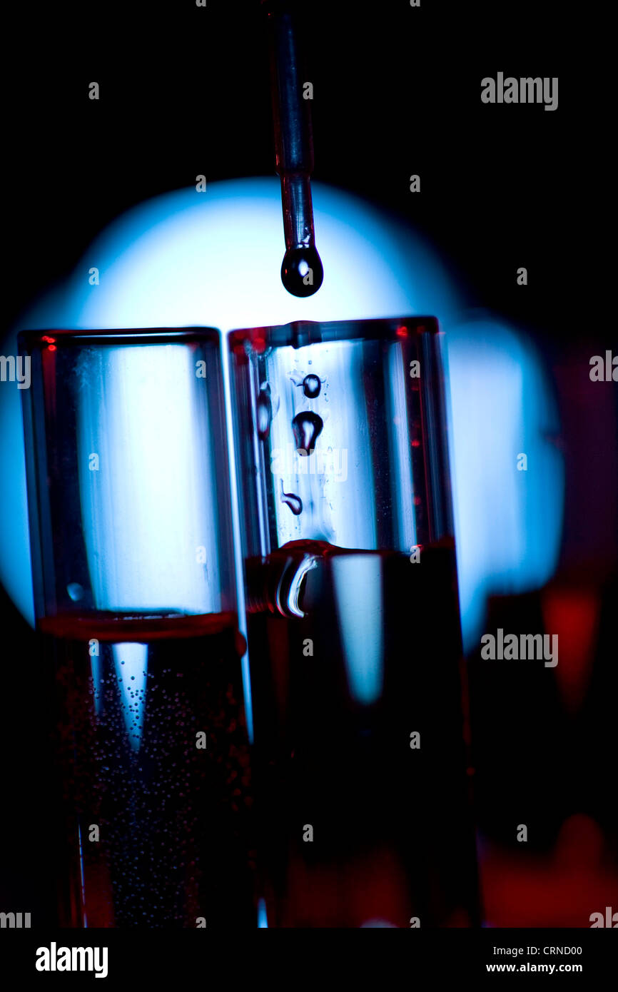 Un pipetage liquide clair dans les tubes à essai. Banque D'Images