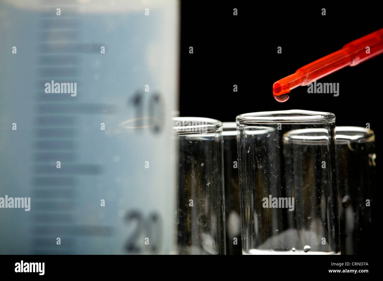 Le pipetage liquide rouge dans les tubes à essai. Banque D'Images