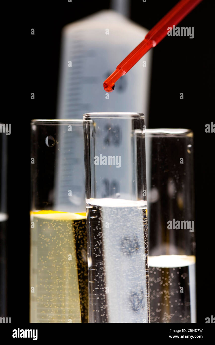 Le pipetage liquide rouge dans les tubes à essai. Banque D'Images