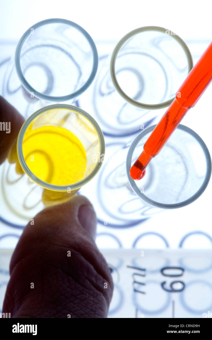 Le pipetage liquide rouge dans les tubes à essai. Banque D'Images