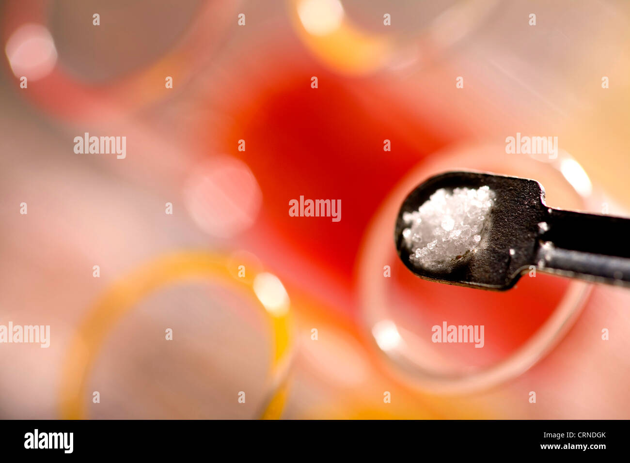 Une spatule de chlorure de sodium (sel de mer) est versé dans un tube à essai. Banque D'Images