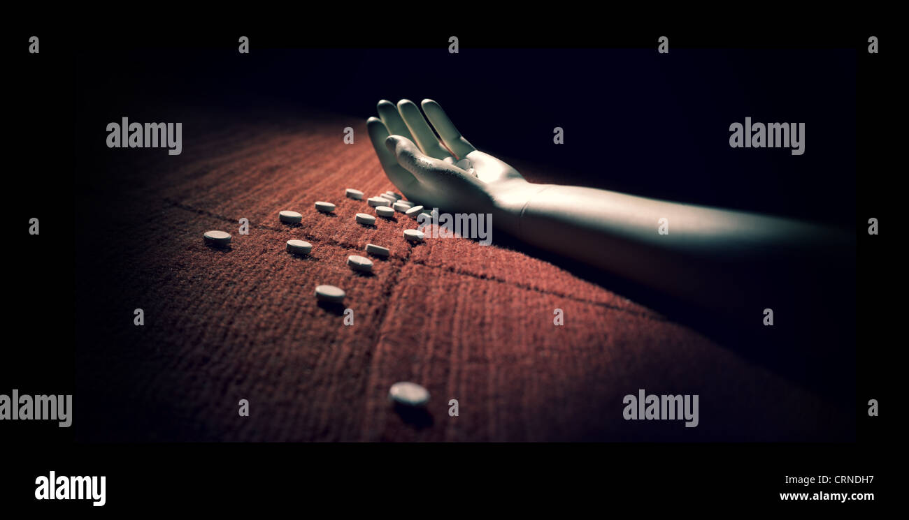 Bras de mannequin sur tapis rouge avec pilules renversé après avoir pris une overdose Banque D'Images