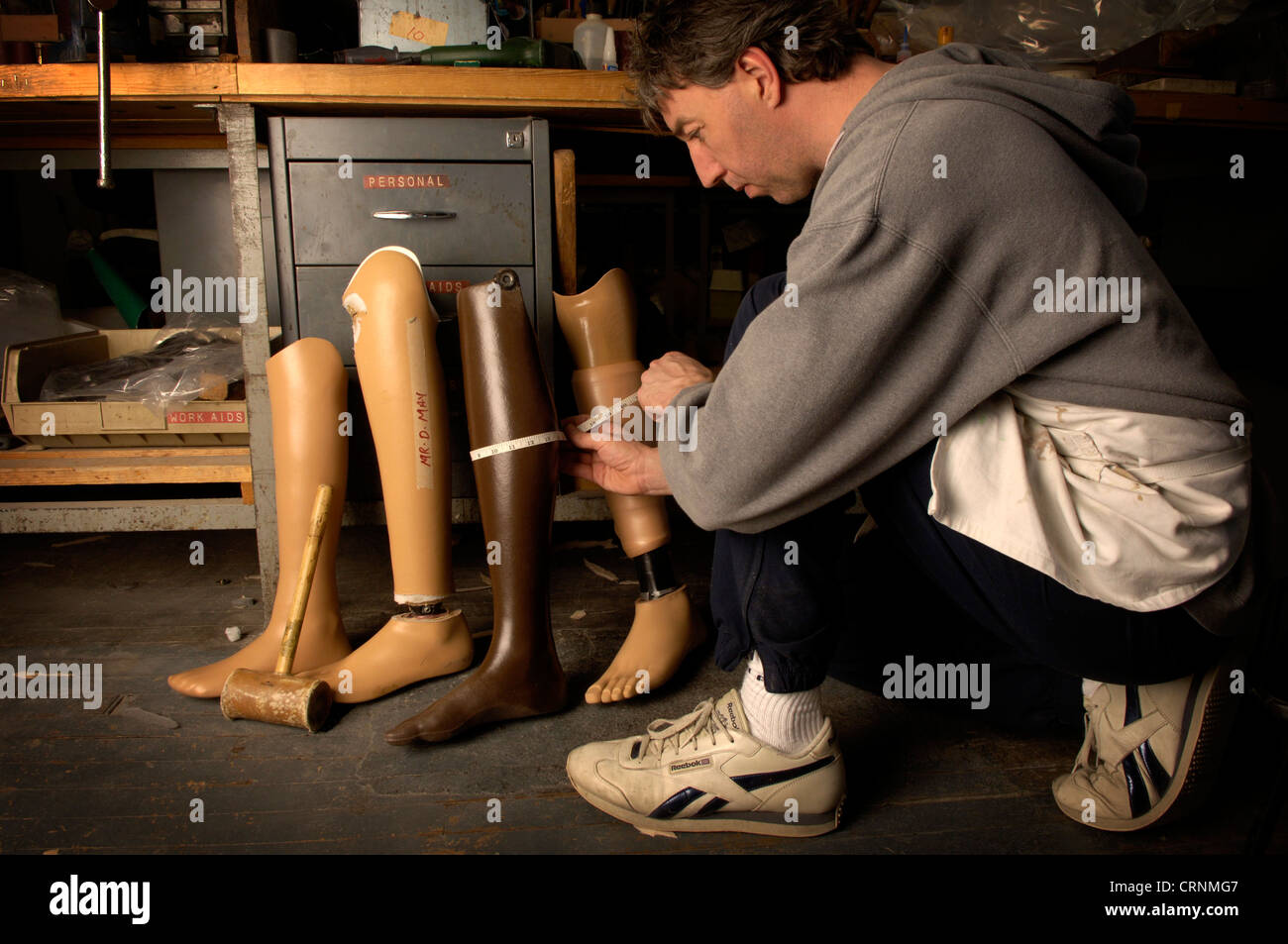 Un technicien dans un centre de rééducation du membre mesure une jambe artificielle pour l'installation. Banque D'Images