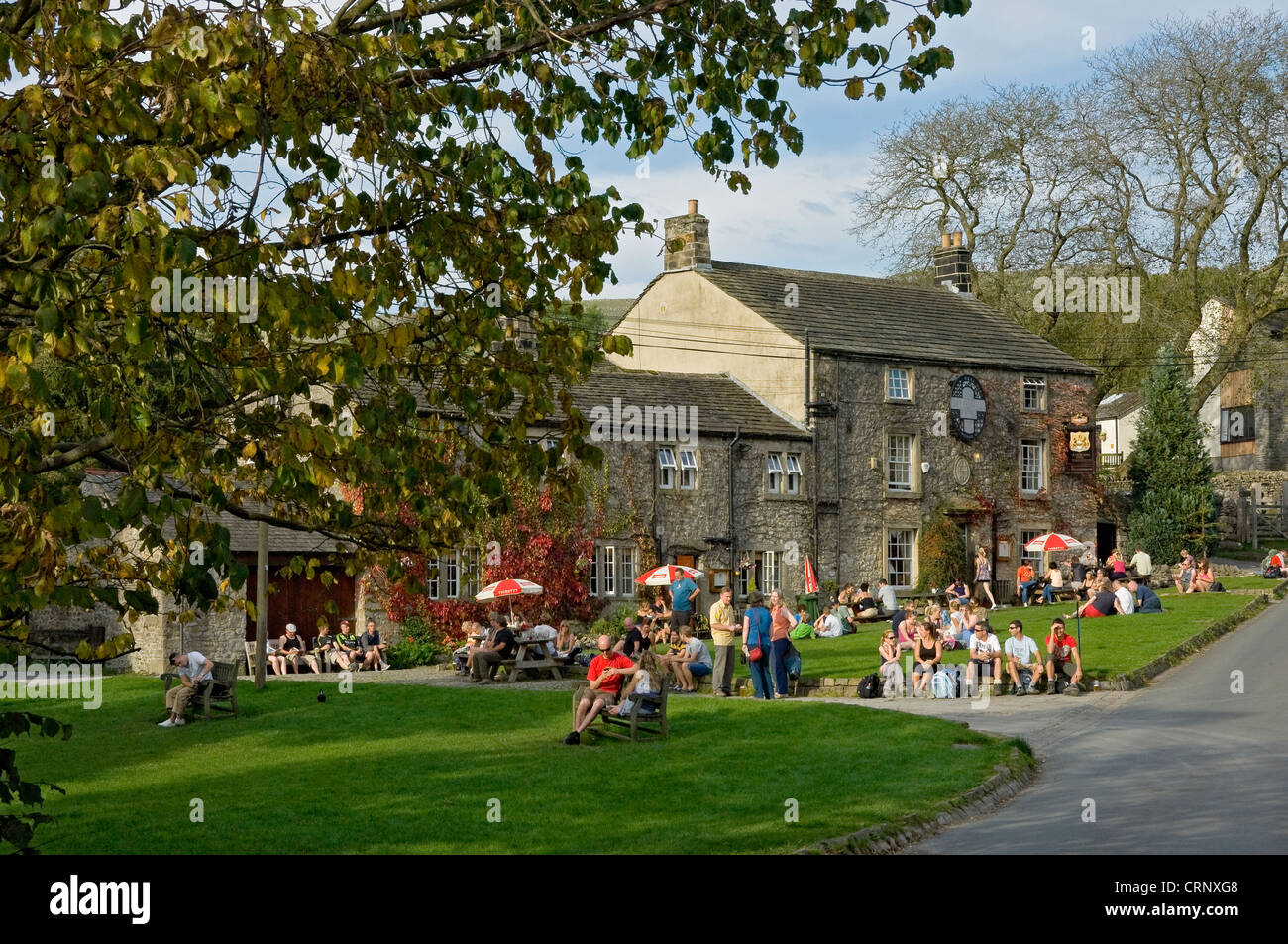 Les touristes en dehors de la détente Lister Arms, une auberge au bas de Malham Cove. Banque D'Images