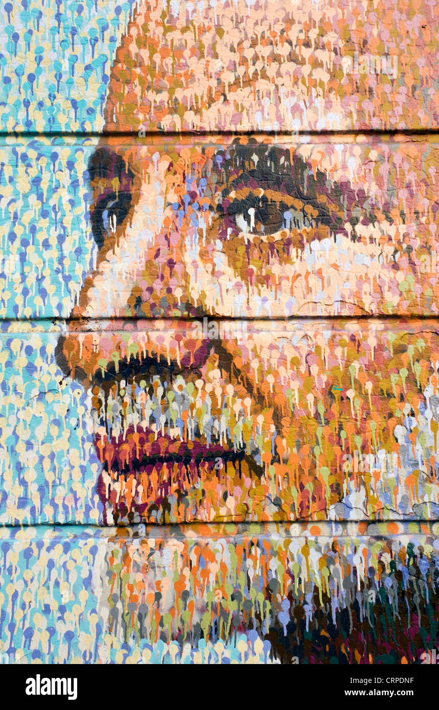 L'art de rue avec un visage peint sur un mur dans le bacon Street dans l'East End de Londres. Banque D'Images