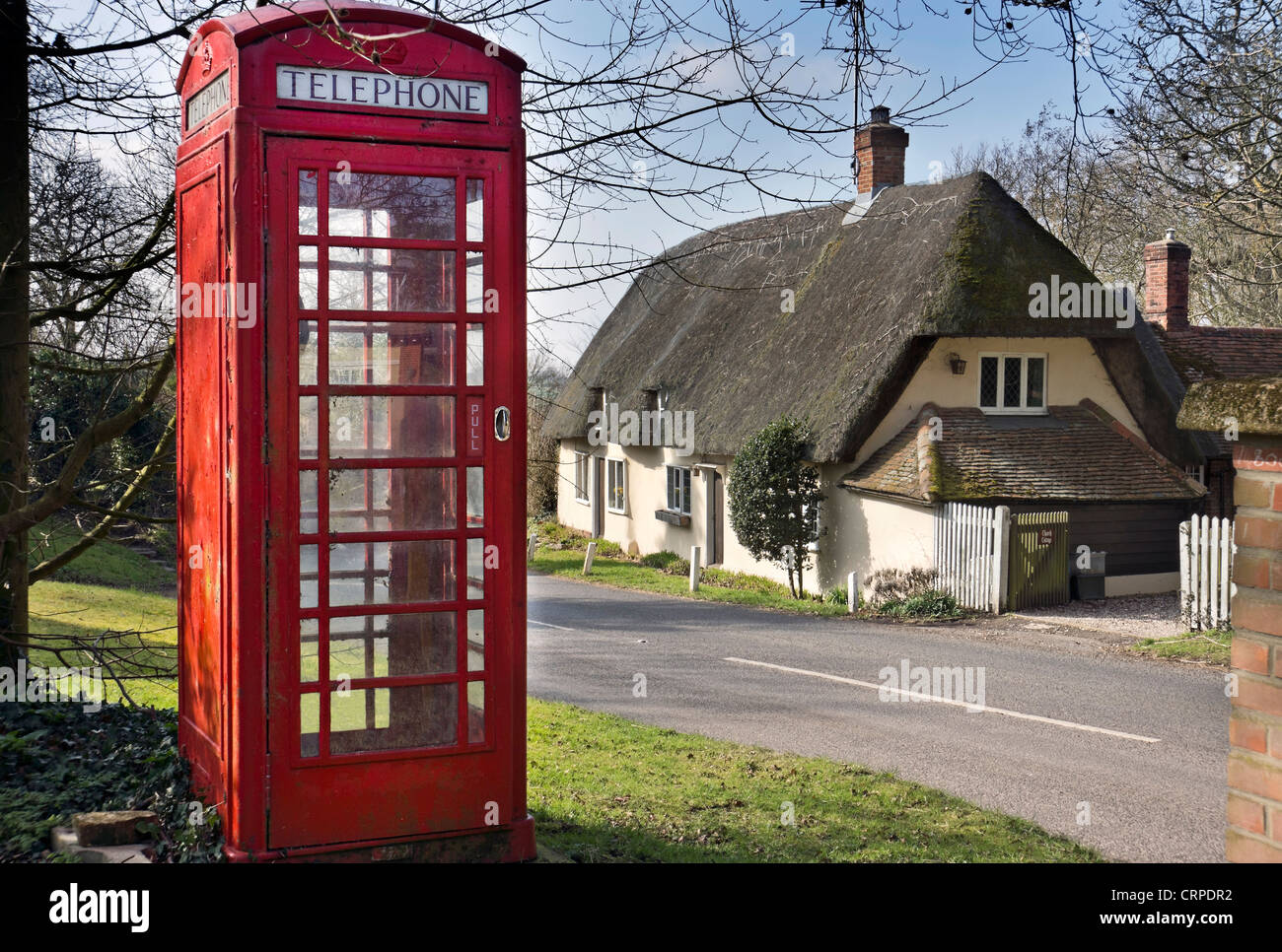 Téléphone traditionnel fort en face d'une chaumière dans le village de Brent Pelham. Banque D'Images