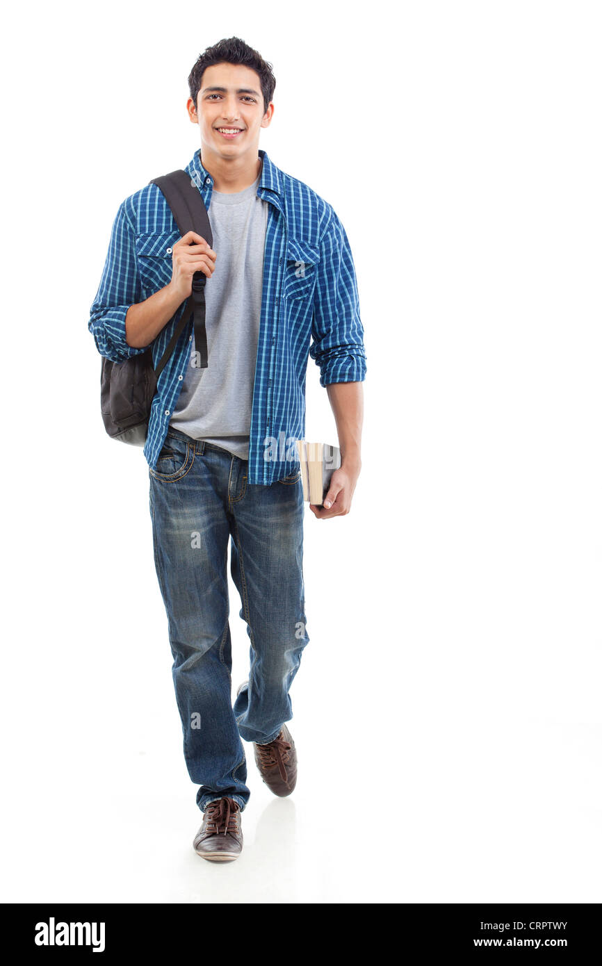 Portrait de jeune homme marchant avec sac et livre sur fond blanc Banque D'Images
