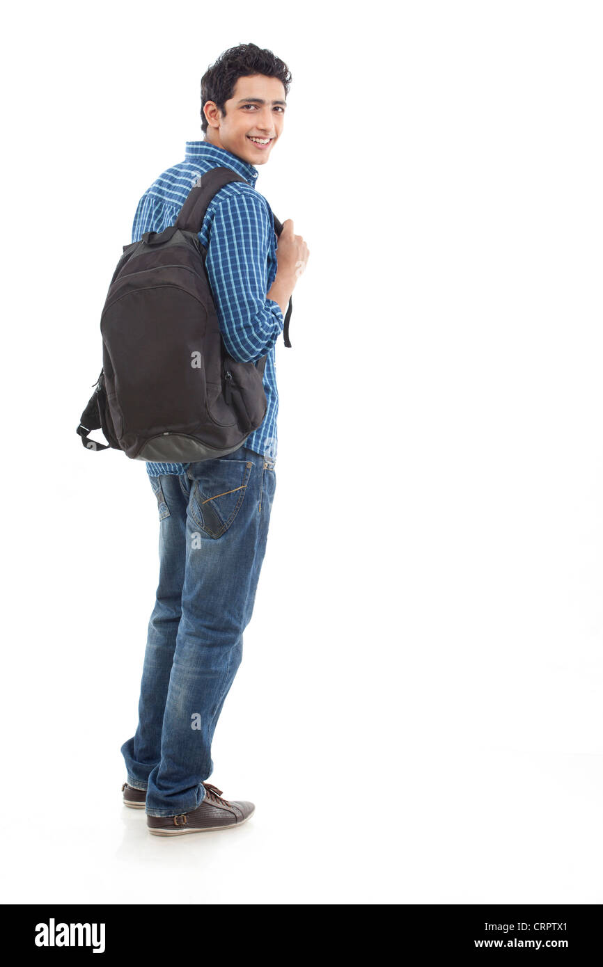 Toute la longueur du jeune homme marchant avec sac against white background Banque D'Images
