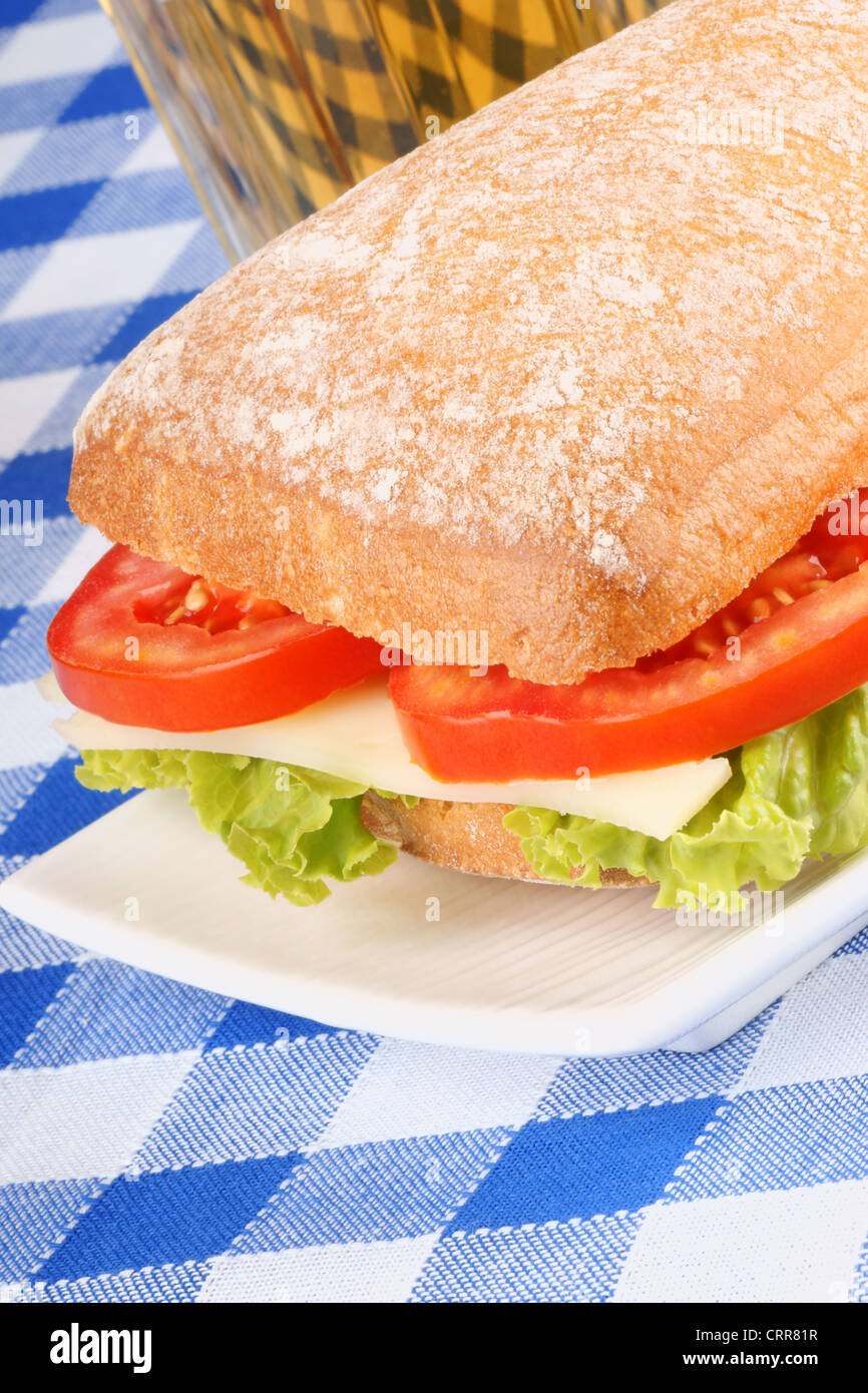 Close-up d'un italien panino (sandwich) avec du pain ciabatta, laitue, tomate et fromage. Banque D'Images