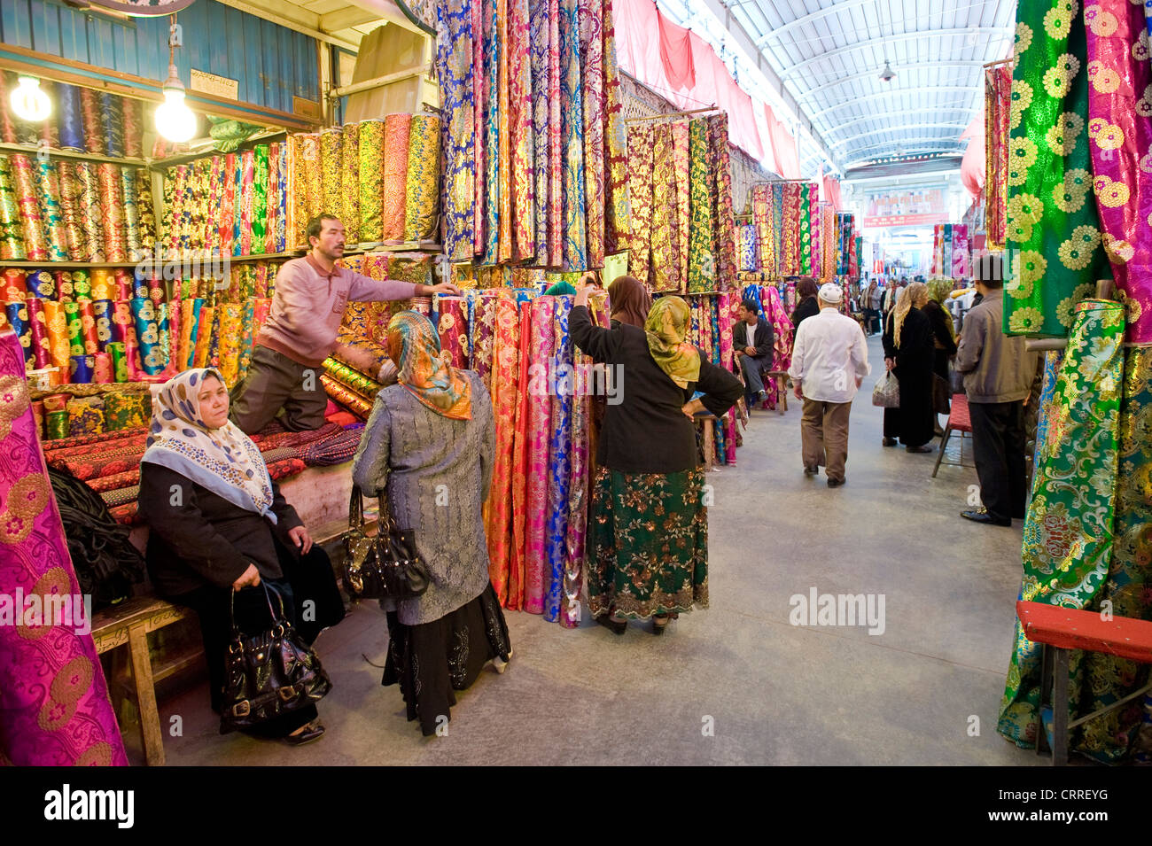 Peuple chinois Ouïghours et les rouleaux de tissu de soie de couleur dans le marché de l'Asie ( Western-Central Bazar) de Kashgar. Banque D'Images