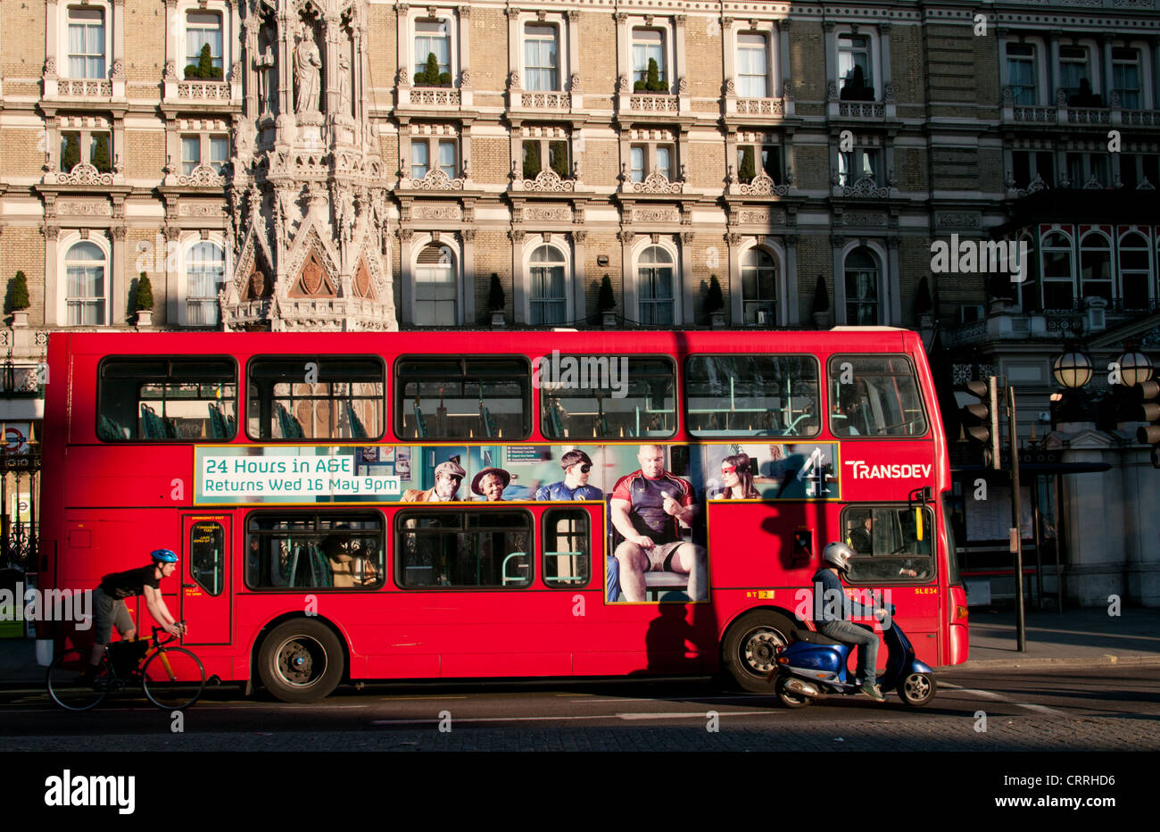 Cycliste du moteur, de cyclistes et de double decker bus rouge de Londres en dehors de Londres Charing Cross hotel et la gare ferroviaire. UK. Banque D'Images