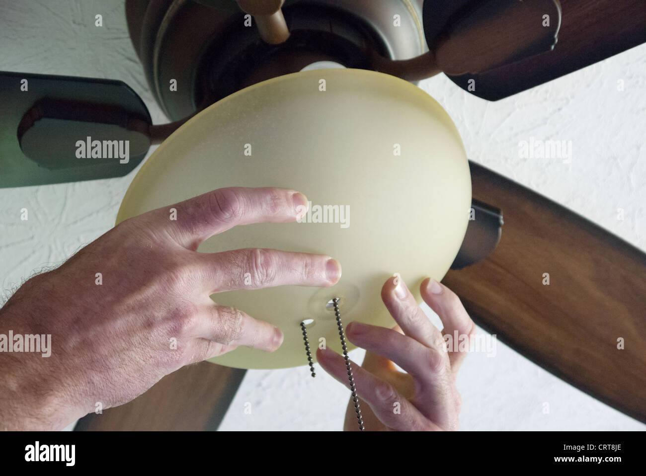 Les mains des hommes montre l'installation d'un ventilateur de plafond Banque D'Images
