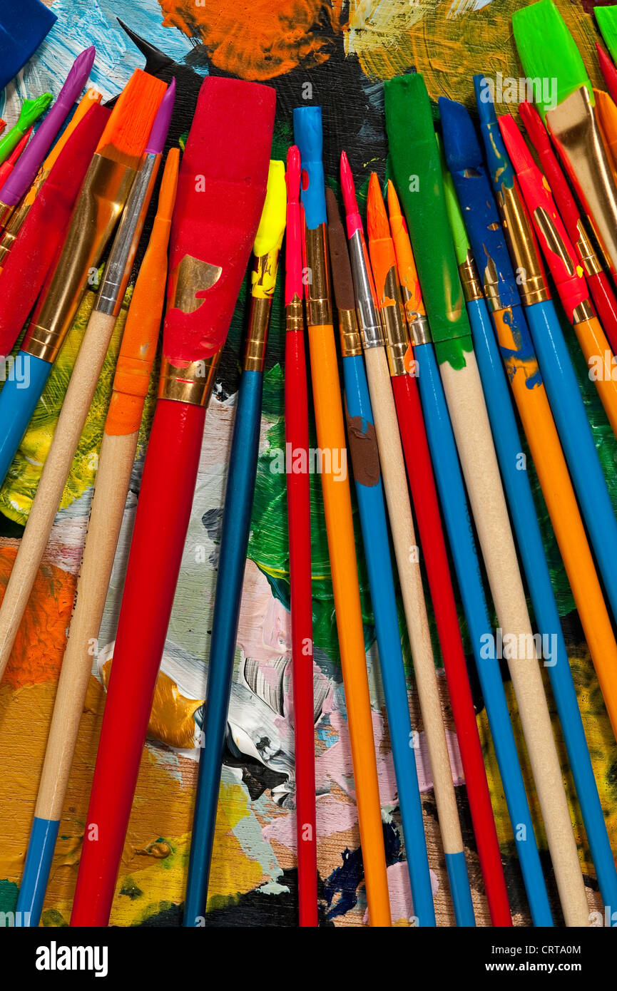 Pinceaux multicolores sur palette colorée Banque D'Images