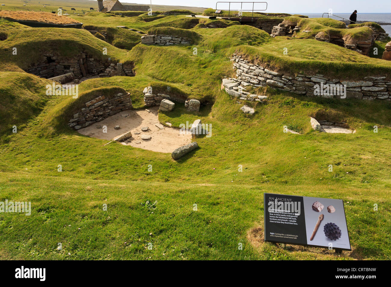 Les excavations d'anciennes maisons de village néolithique préhistorique à Skara Brae avec signal d'information. Orkney Islands Scotland UK Banque D'Images