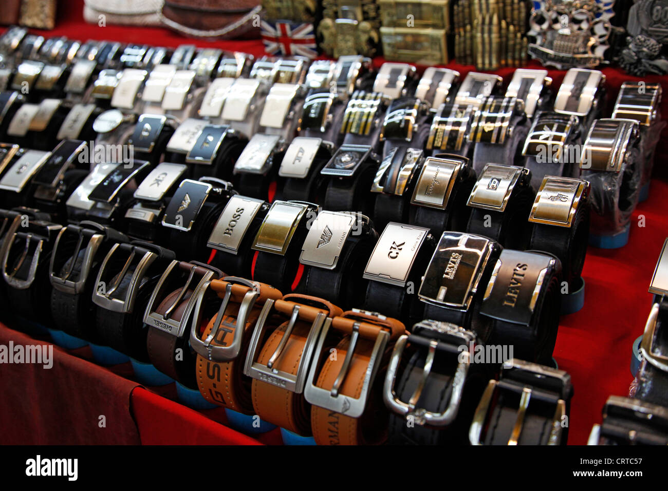 La vente de marchandises de contrefaçon et des ceintures de créateur sur un étal au marché nocturne de Patpong à Bangkok, Thaïlande. Banque D'Images