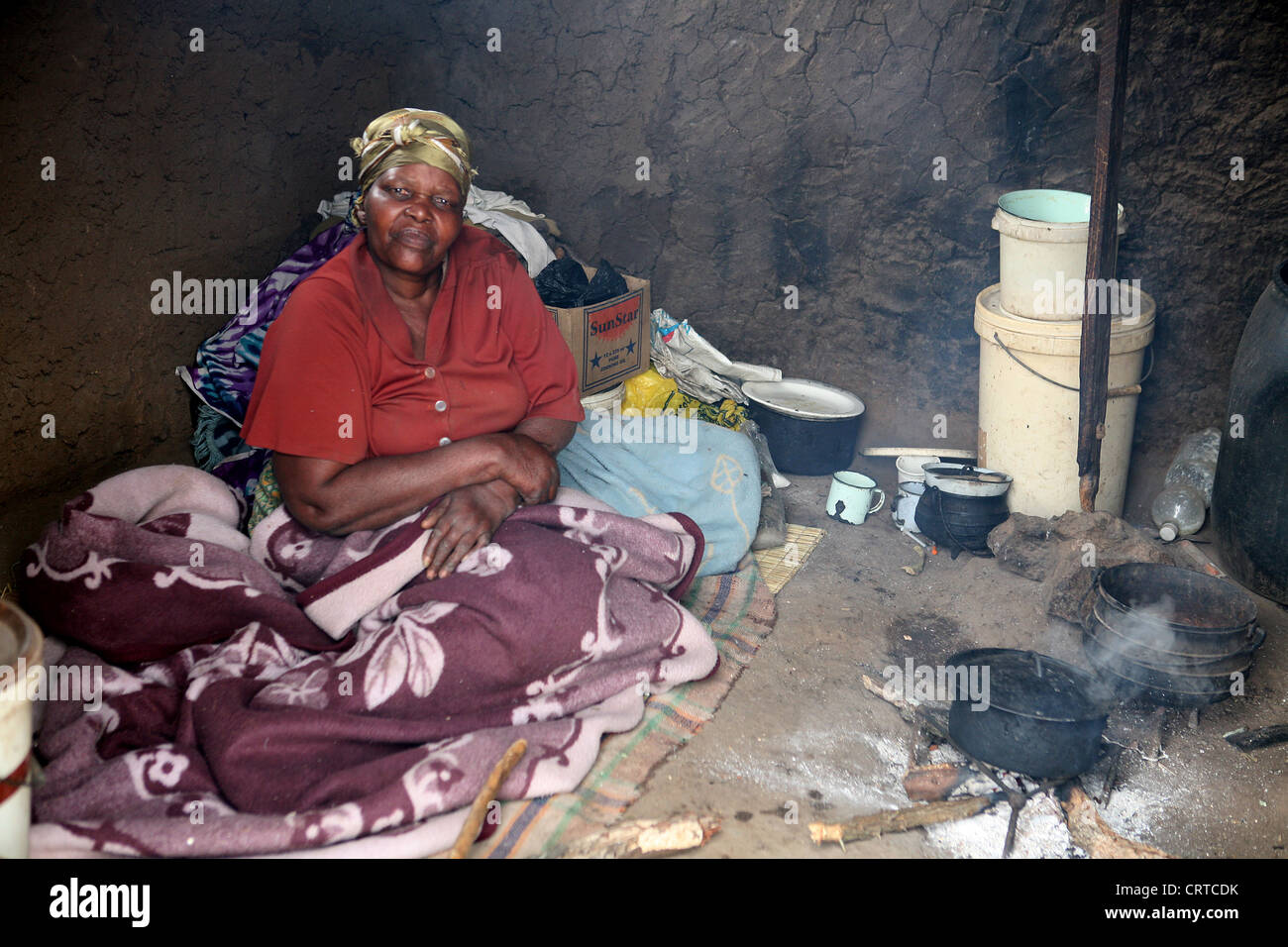 Femme assise à l'intérieur d'une hutte en terre, Swaziland, Afrique Banque D'Images
