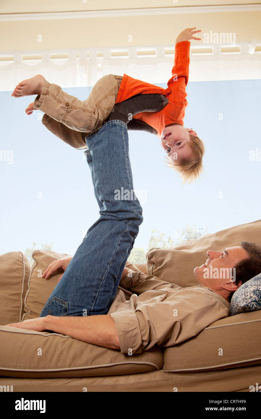 Père jouant avec son fils sur le canapé. Banque D'Images