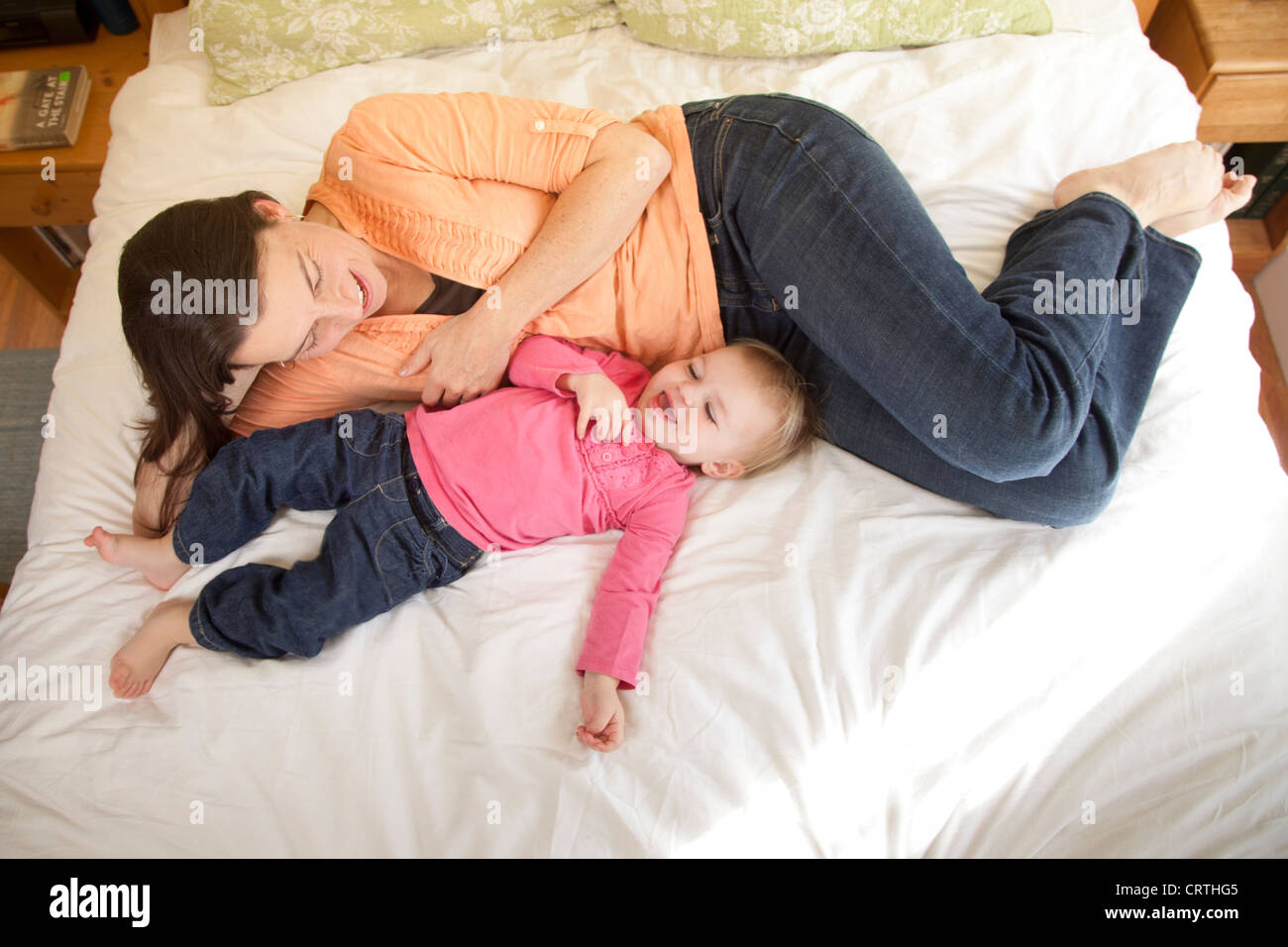 Une mère et sa fille couchée sur le lit ensemble. Banque D'Images