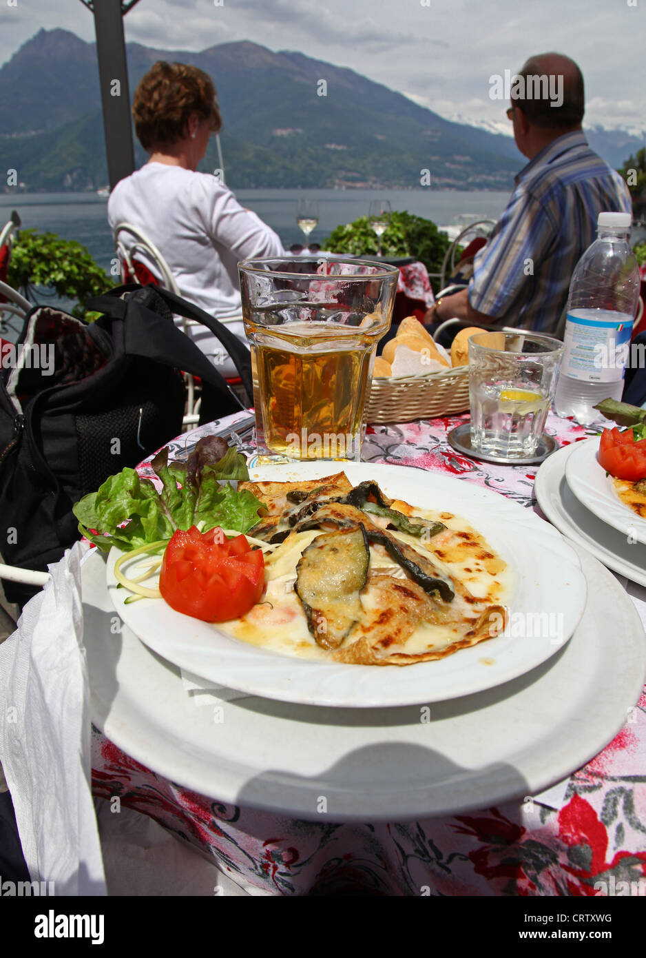 Les Épinards et crêpe aubergine sur une table à un restaurant ou un café en plein air donnant sur le lac de Côme Varenna Italie Banque D'Images