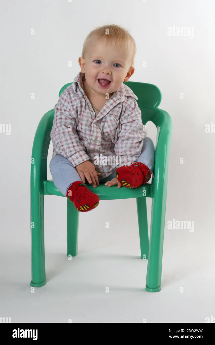 Un heureux petit enfant sur une chaise Banque D'Images