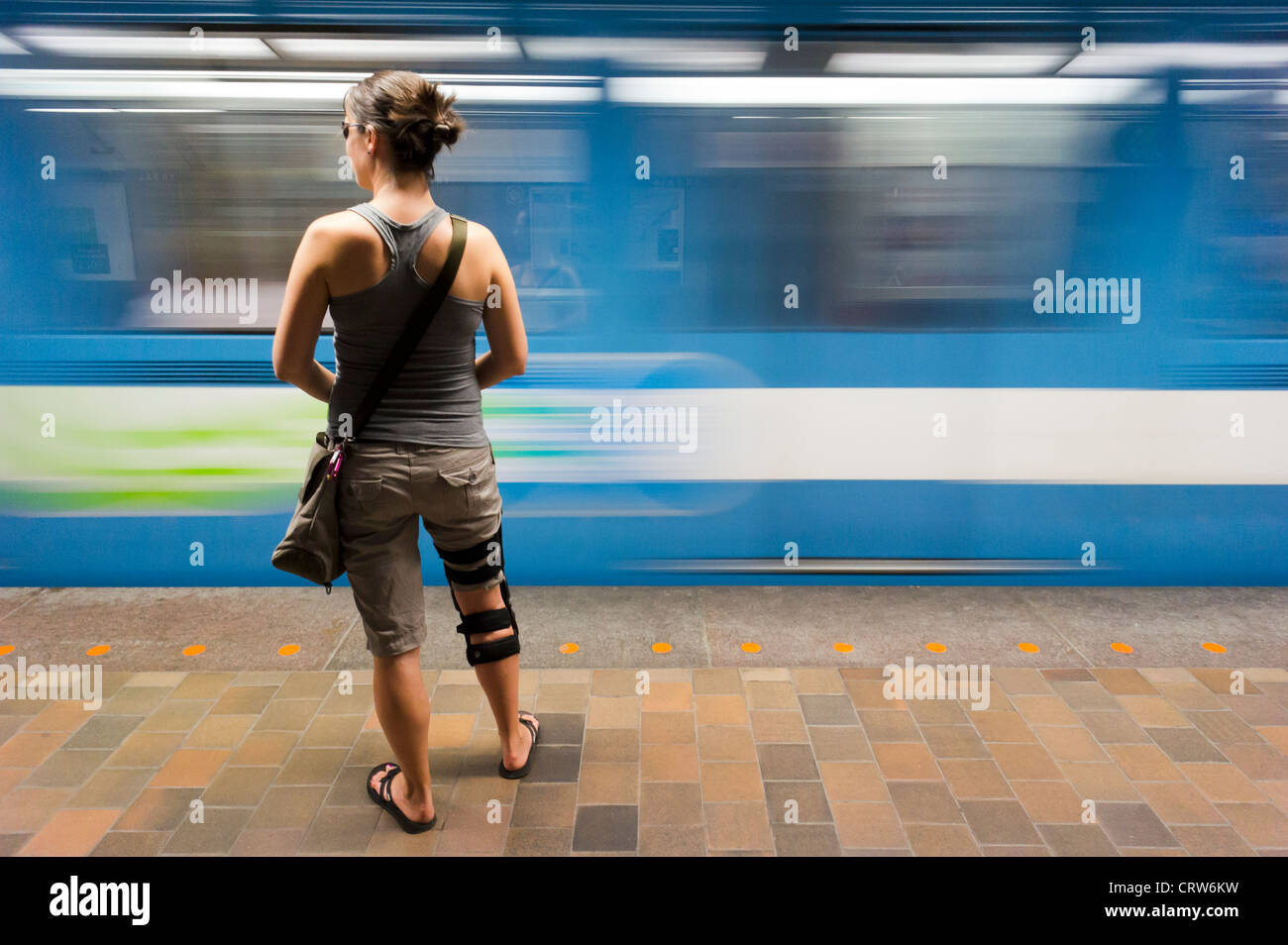 Fille avec attelle de genou à la station de métro. Montréal, Québec, Canada. Banque D'Images