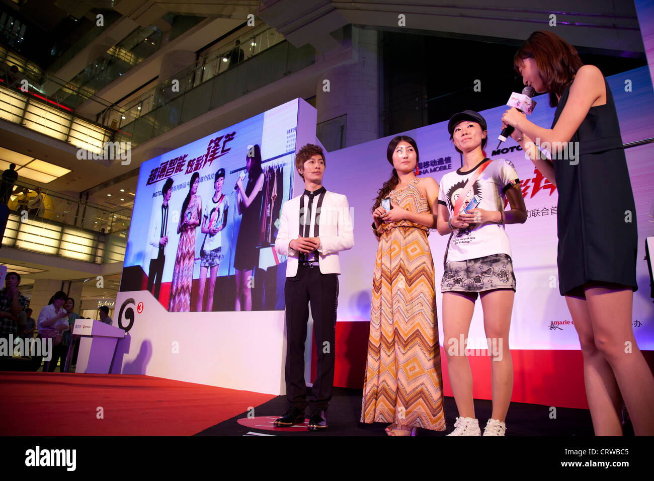 Les présentateurs sur scène à un événement promotionnel PR par compagnie de téléphone cellulaire Mororola. Joy City Shopping Mall, Xidan, Beijing. Banque D'Images