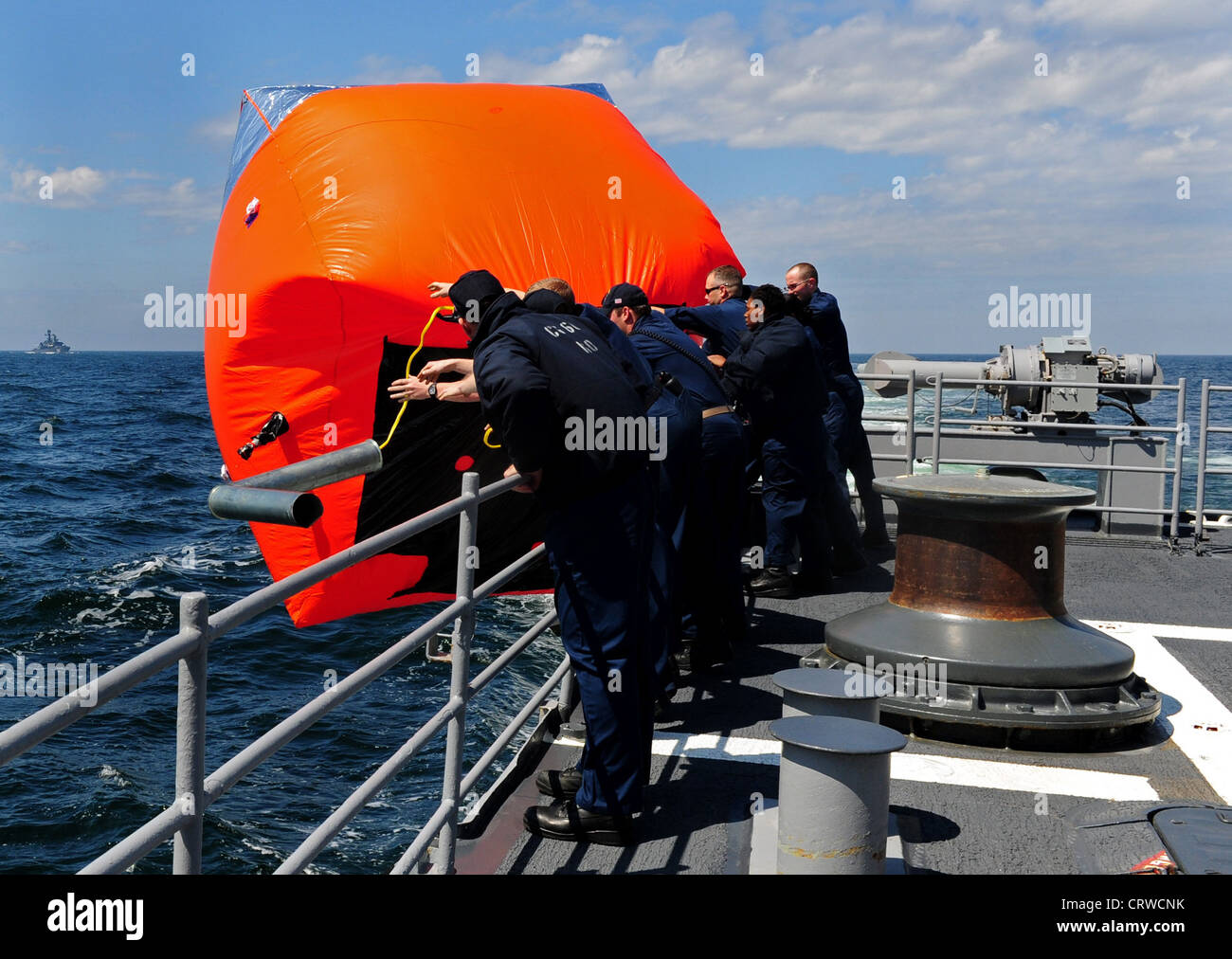 Les marins à bord du croiseur à missiles guidés USS Normandy (CG 60) déploient une cible flottante appelée « tomate tueur » en préparation à un exercice d’armes à feu direct à l’appui de l’exercice d’entraînement multinational FRUKUS 2012. FRUKUS est un exercice annuel visant à améliorer la sécurité maritime par un dialogue ouvert et une formation accrue entre les marines de France, de Russie, du Royaume-Uni et des États-Unis. Banque D'Images