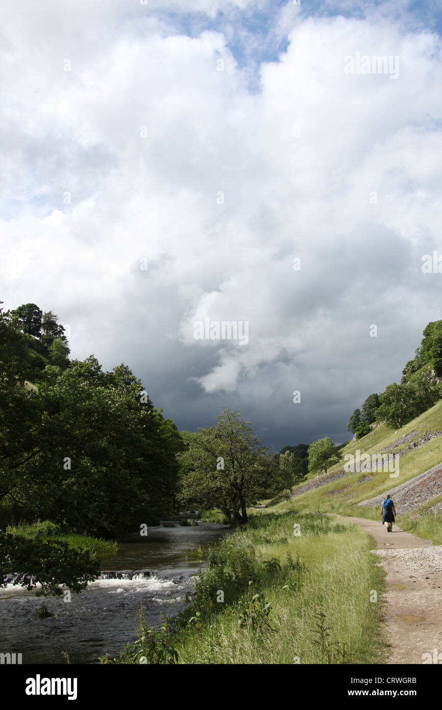 Randonneur dans Wolfscote Dale par la rivière Dove Banque D'Images