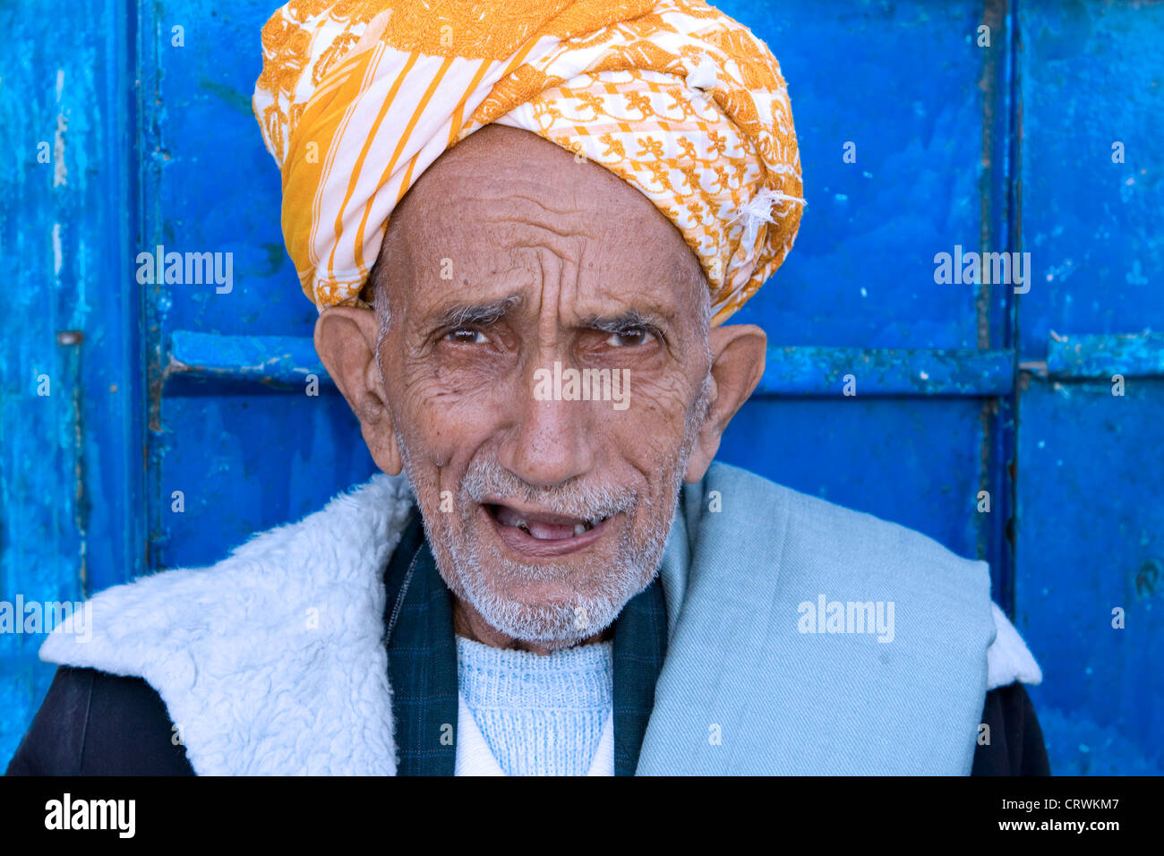 Vieil homme contre une porte bleue, montagnes Haraz, Manarkha, Al-Mahwit, Yémen Banque D'Images