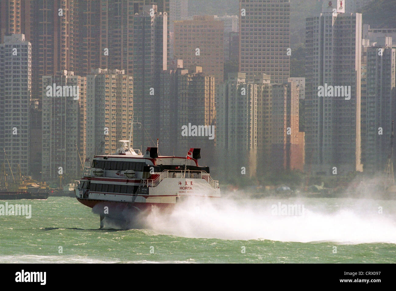 Un bateau de vitesse sur l'eau en face de Hong Kong Banque D'Images