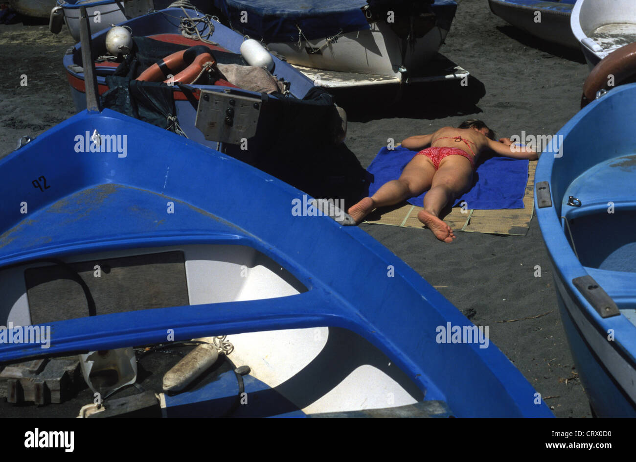 Femme couchée dans un espace confiné entre les bateaux Banque D'Images