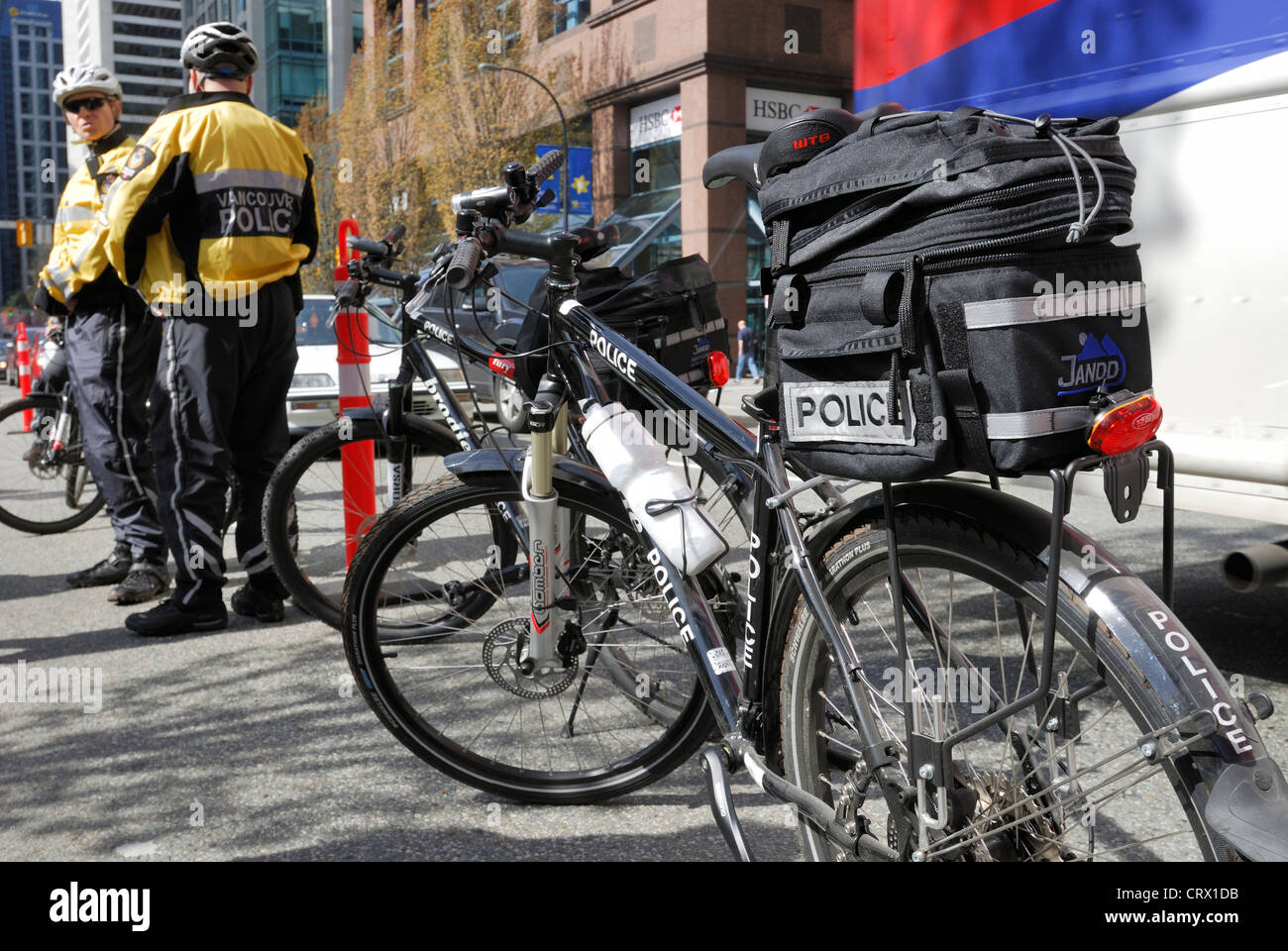 Vancouver Police vélos garés, avec des agents à proximité. Banque D'Images