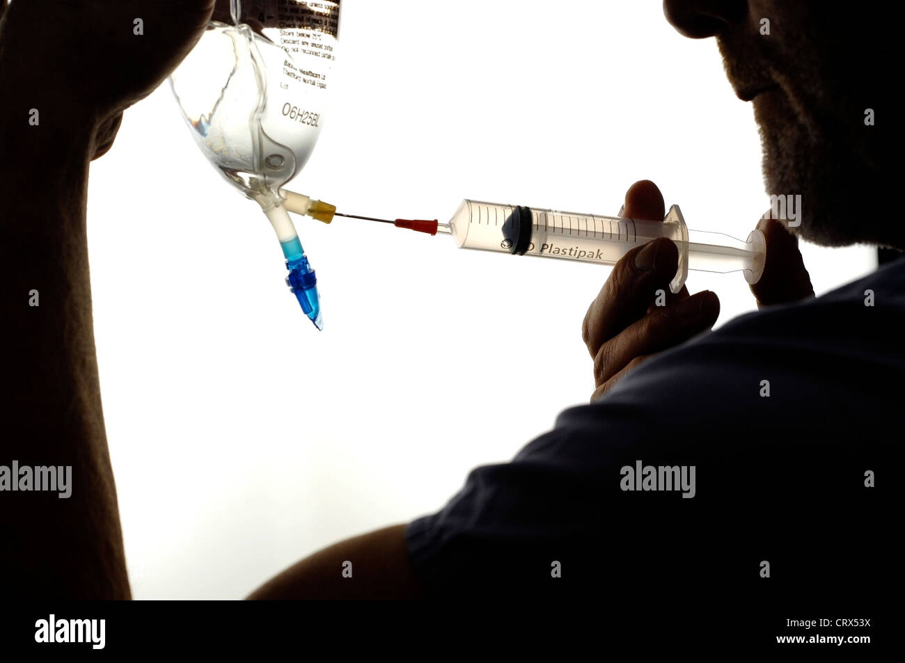 Une solution de lactate de sodium étant tiré d'un sac dans une seringue. Banque D'Images